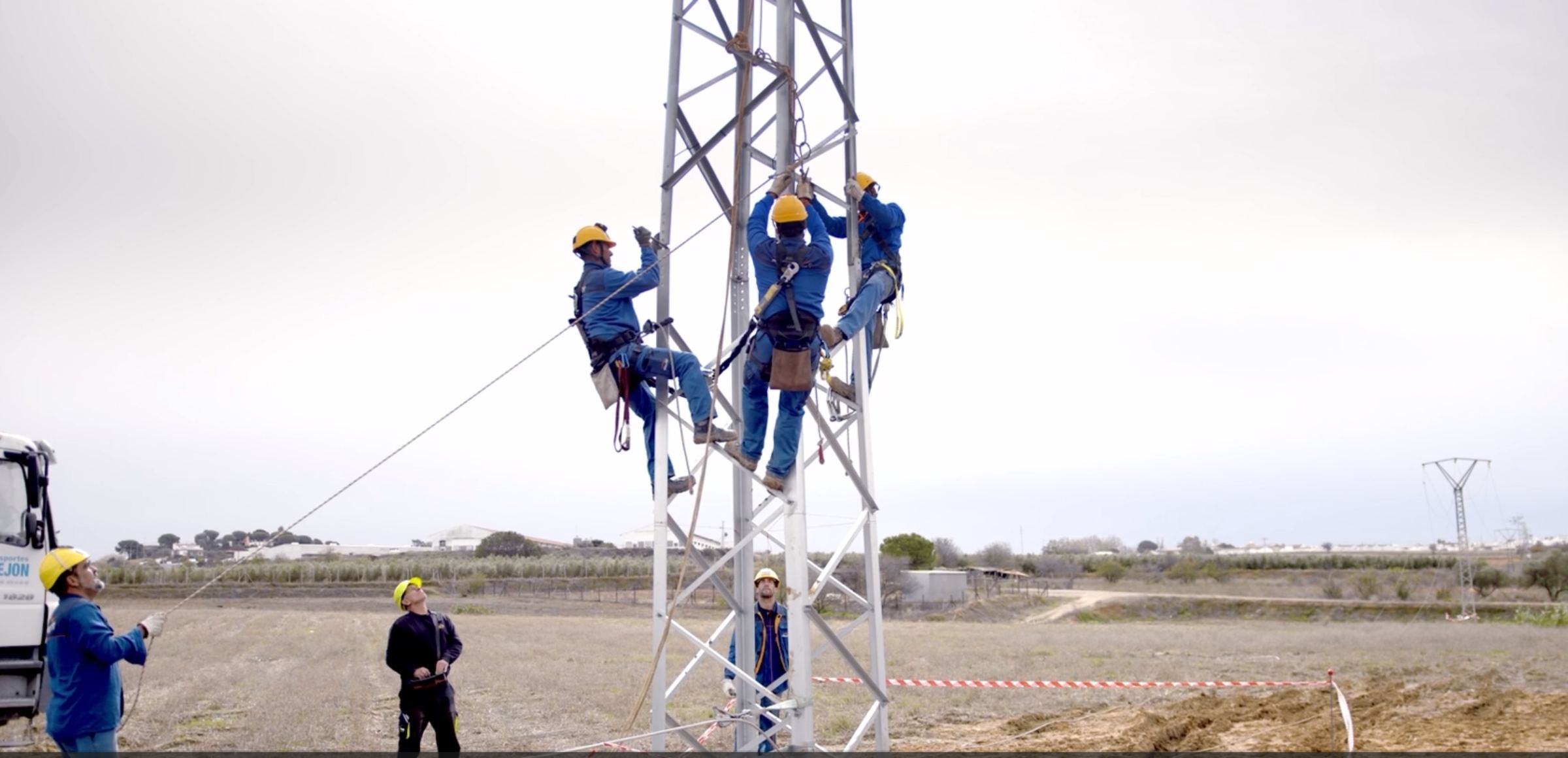 Operarios de Endesa realizando labores de mantenimiento en líneas de alta tensión con medidas de seguridad.